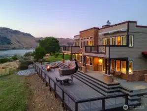 Exterior twilight view 1 of home w/ decks and outdoor living areas.
