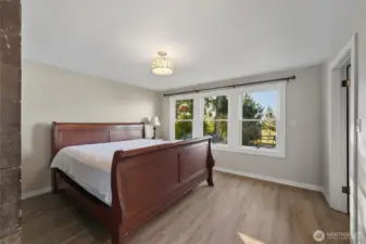 Primary bedroom with views looking west.  Walk in closet and main bathroom on the right.