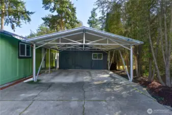 Detached outbuilding and covered carport providing parking and storage