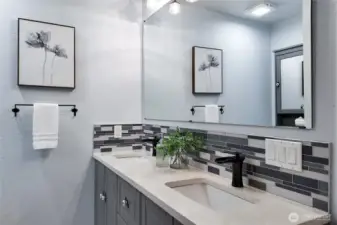 Double vanity bathroom with updated fixtures and tile backsplash
