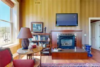 Inviting reading and relaxing space – built-in shelves, cozy fireplace, and soft natural light.