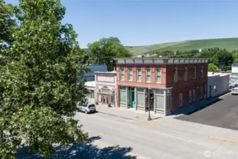 Aerial perspective – storefronts below a window-wrapped apartment.