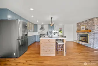 The eat in kitchen is on the right side upon entry with the gas fireplace