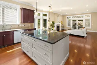 Dream kitchen boasts high-end appliances, including a Bosch refrigerator and dishwasher. Features include a stylish tiled backsplash, glass pantry door, spacious central island with cabinetry, slab granite countertops, and an elegant breakfast nook that flows from the family room to the outdoor retreat. Abundant natural light completes the space.