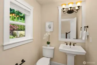 Powder room on the main floor, tucked at the corner of the staircase.