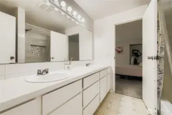 Full upstairs bathrooms with dual sinks, plenty of storage, and updated tile surround bathtub