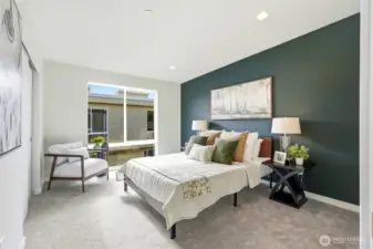 The upper level Primary bedroom has a floor-to-ceiling window that floods the room with light, as well as a walk-in closet and access to the shared bath.