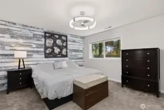 Spacious primary bedroom with modern lighting and ceiling fan