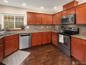 Entertain effortlessly in this generous kitchen with wood cabinets and beautiful flooring. You can just smell the coffee brewing now.