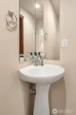Elegant pedestal sink graces the main floor half bath.
