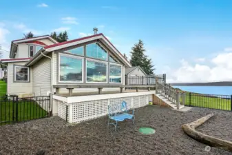 View of the water side of the house from inside the fenced backyard.