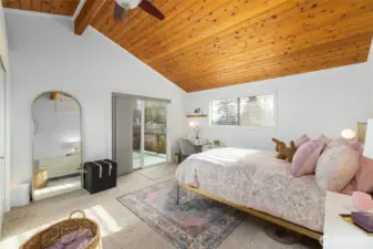 Relax in the spacious, main-level primary suite with view deck and soaring, natural wood ceilings.