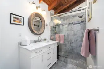 Skip bathroom renovation and relish this handsome, step-in tile shower with glass doors, tile flooring along with the new vanity, fixtures, lighting and a full wall of custom storage cabinets.
