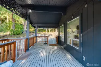 The extensive deck surrounding the home also offers a covered outdoor grilling and dining area, ideal for entertaining.