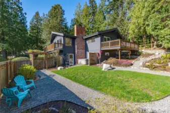 Large and lovely firs wrap this classic NW contemporary home set on a wide lot, lending privacy, and play space.