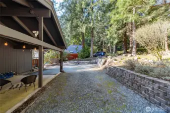 Under-deck storage, a deep carport and ample, additional  parking with back-up space suit many vehicles and suggest options for a potential, future covered garage.