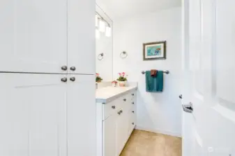 Never vanity, linen closet, lighting and recycled glass countertop.