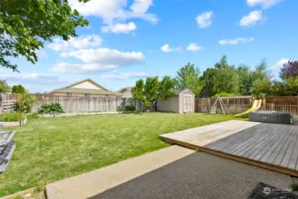 Large backyard with garden space and a wood deck.