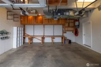 Park in comfort in the large 2 car garage with built in storage and workbenches.