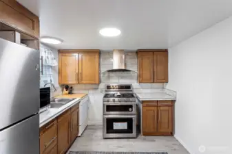 Popular redesign for these classic Tacoma split levels is to remove the wall between living and kitchen to modernize the floor plan and create a more open feel.  This space is ready for it!
