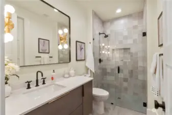 Main floor bathroom connected to the second primary bedroom is also accessible to guests by hallway entrance.