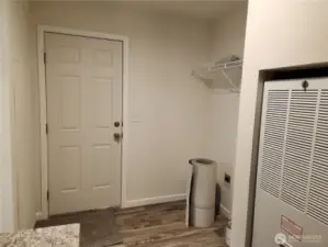 Door in utility room leads to back porch.  To the right of the door is space for a washer and dryer.  Furnace in view.