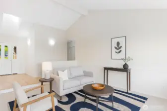 Here is the large living room staged (virial) looking back at the entry with the hallway leading to the bedrooms.  The high vaulted ceilings gives this an expansive space feel.