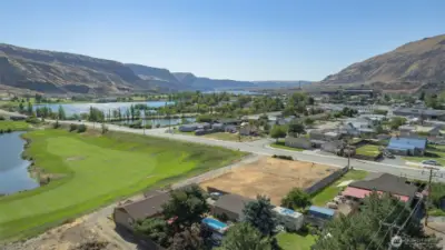 Aerial View of Lot – Panoramic perspective showcasing the .32-acre flat, buildable lot with sweeping views of the Rock Island Golf Course and surrounding mountains.