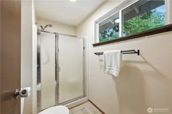 Primary bath has shower and a window to let in natural light.