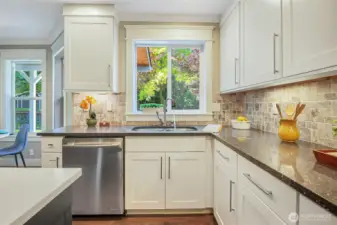The quartz counters coordinate with the color theme of the kitchen. Note the custom moldings and trim.