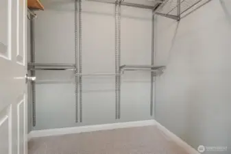 A walk in closet with sturdy fully-adjustable shelving.