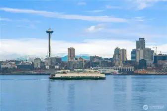 The Seattle skyline is backed by the Cascade mountains and fronted by the always moving marine traffic of Elliott Bay.
