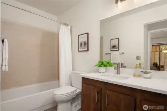 The main bath features an oversized vanity with new quartz counters, new LVP flooring and new lighting.