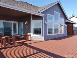 Rear view of this home with large windows, and a huge deck.