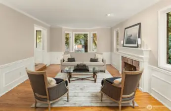 The living room continues the design style throughout the main floor featuring wainscotting, crown molding and attractive trim details.