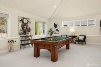 Spacious main-level recreation room just off the kitchen and family room, ideal for entertaining. Vaulted ceilings and tranquil backyard views create a light-filled retreat, while a walk-in closet with a home safe and a second staircase add convenience and function. Adjacent to a rare main-floor ¾ bath, the versatile space offers endless possibilities for a billiards room, guest suite, executive office, playroom, or multi-generational living. The home safe and pool table are included!