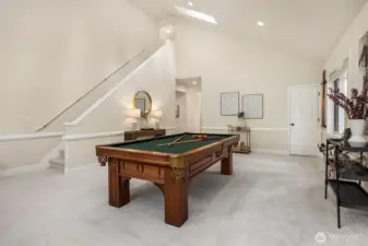 Versatile main-level recreation room conveniently located off the kitchen and family room, perfect for gatherings and game nights. Vaulted ceilings and peaceful backyard views fill the space with natural light, while a second staircase enhances the home’s thoughtful layout. The room includes a walk-in closet with a home safe, and sits adjacent to a rare main-floor ¾ bath - ideal for use as a billiards room, executive office, guest suite, playroom, or multi-generational living space. Pool table and home safe are included.
