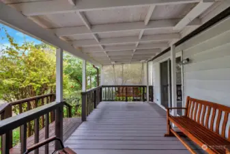 Private, covered back deck is accessible from the living room and the primary bedroom. Great space for a gathering of friends. Room for BBQ and more. Steps from the deck take you to the private yard. Enjoy the greenery, mature trees and shrubs all year round.