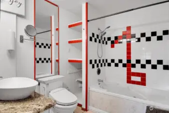 Full tile-and-granite bathroom in artistic white, red and black design. Jetted Jacuzzi tub.