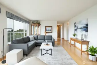 Virtually staged living room has a wall of windows to look at the views