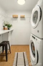 The laundry room with newer stackable washer/dryer and plenty of storage space.
