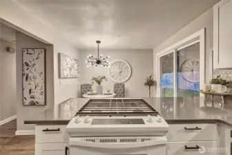 Charming kitchen with quartz countertops and gas stove.