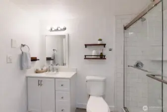 Master bath featuring walk-in shower enclosed with clear glass and finished with classic white subway tile. The photo is virtually staged.