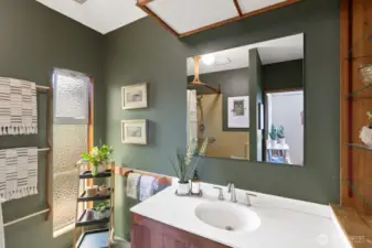 The primary bathroom, with the shower reflected in the mirror.