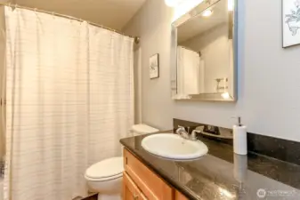 Updated full bathroom off the primary bedroom with granite countertops, modern vanity, and a tub shower combination with neutral finishes—perfect for easy everyday living.