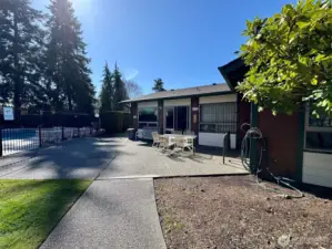 Clubhouse patio overlook the pool, with a bike rack and exterior hose.