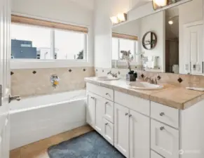 Spacious primary bathroom with two sinks, soaking tub, and shower.