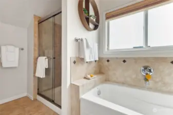 Spacious primary bathroom with two sinks, soaking tub, and shower.