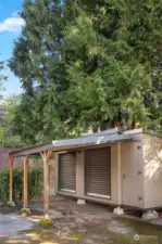 Storage building with carport area to the right of the driveway