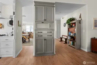 Looking into the Living and dining room from the Kitchen . The kitchen is adorned with custom cabinets.  You are looking at the pantry with a space for the microwave.